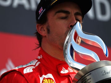 Fernando Alonso besa un trofeo en el podio